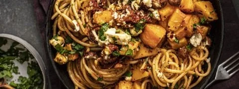 Pasta mit Kürbis und Feta, serviert auf einem Teller